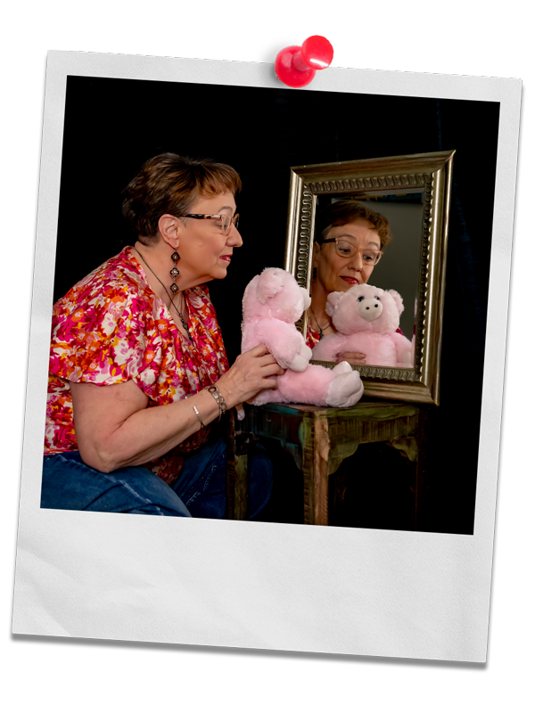 Photo of Coach Delisa with a teddy bear looking into a mirror