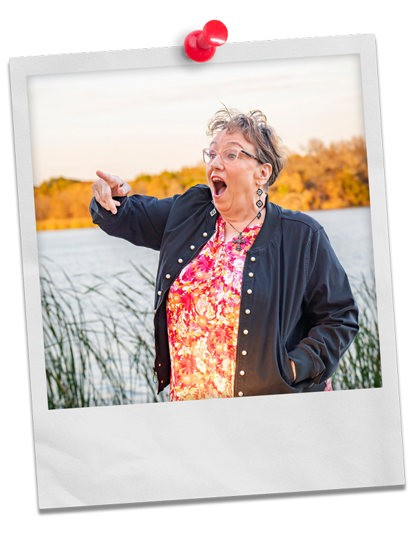 Photo of Coach Delisa at a lake or pond pointing to something off-camera